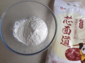 细砂糖和酵母倒入温水中，搅拌溶解，面粉和奶粉倒入和面盆中