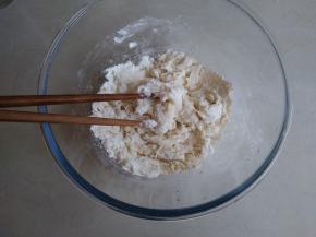 将酵母水和油倒入面粉里，用筷子搅拌成絮状