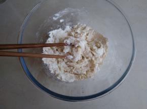 将酵母水和油倒入面粉里，用筷子搅拌成絮状