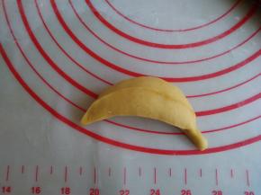 捏紧收口，收口朝下，搓一搓，让果肉和蕉皮更紧密一点，再用拇指和食指捏出3、4条楞，一端捏出香蕉柄，做好的香蕉放在蒸锅里，下面垫上硅胶蒸垫