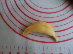 捏紧收口，收口朝下，搓一搓，让果肉和蕉皮更紧密一点，再用拇指和食指捏出3、4条楞，一端捏出香蕉柄，做好的香蕉放在蒸锅里，下面垫上硅胶蒸垫