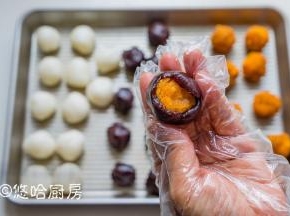 红豆沙用手捏开，包入蛋黄肉松，包紧并收口。