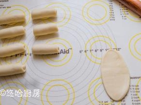 取一个醒发后的面团压扁、翻面、上下擀开，从上至下卷起，依次做好全部，盖保鲜膜防止表皮干燥，继续醒发15分钟。