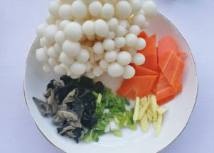 木耳温水泡发洗净，胡萝卜去皮切菱形，葱切末，姜切丝。