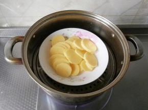 土豆切薄片，一定要切薄一点，比较容易蒸，放在盘子里。蒸锅里放入小半锅冷水，直接冷水上锅蒸，开大火，盖好锅盖，蒸15分钟，蒸到用筷子能轻易戳洞即可。