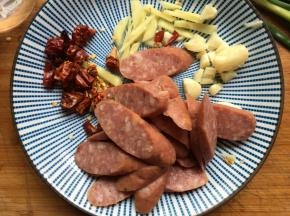 牛肉肠切片，生姜、大蒜、干红辣椒切碎；
