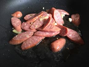 继续倒入牛肉肠，中小火煎至两面金黄；
