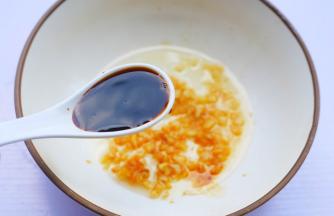 准备一个大碗，加入一半蒜末，加2勺生抽，