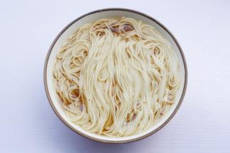 煮好的面条盛入调料碗中，码入准备好的配菜。