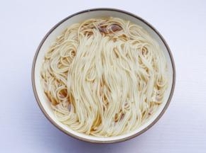 煮好的面条盛入调料碗中，码入准备好的配菜。