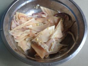 再切成一片片小块鱿鱼，用姜蓉、酒腌一会