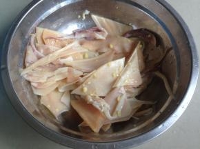 再切成一片片小块鱿鱼，用姜蓉、酒腌一会