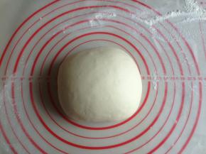 面团发酵两倍大后，把面团取出放在案板上不停的揉，大概揉几分钟，面团重新揉至光滑