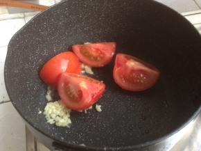 锅里加油倒入蒜蓉，加入番茄，炒软