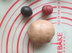 10克的加食用竹炭粉揉成黑色粉团，7克的加红曲粉揉成红色小粉团，105克的加可可粉揉成灰色的粉团（别看灰色的颜色这么淡，蒸好后就和成品图一样深色）