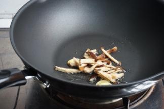 锅里加油，烧热加姜片，倒入香菇丝，煸炒几下