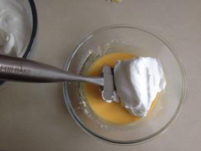 鸡蛋清加入柠檬汁后，分三次加入细砂糖，用电动打蛋器打至湿性发泡。用刮刀将三分之一的蛋白霜加入到蛋黄糊里，从底部向上翻拌均匀，不可划圈翻拌