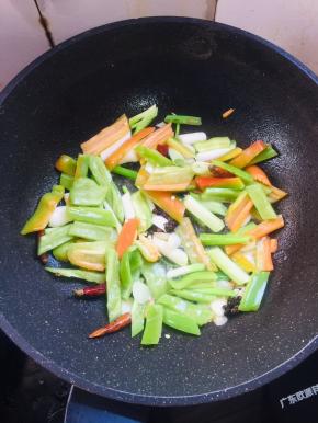 锅烧热倒入适量的油，放入蒜瓣，生姜，花椒，干辣椒，葱，青椒，红椒爆香。