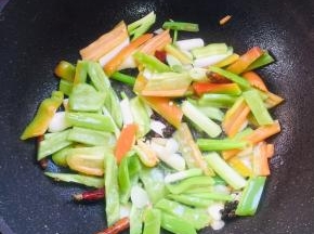 锅烧热倒入适量的油，放入蒜瓣，生姜，花椒，干辣椒，葱，青椒，红椒爆香。