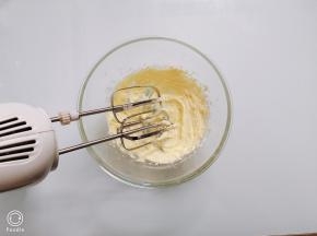 先不开启电动打蛋器，用打蛋器头搅拌一下，再启动电源，打发至黄油颜色变浅、体积变大的状态，看不到糖粉