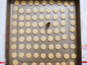 放入不沾烤盘中，然后用小一号的花嘴在圆形面片上轻轻压出小圆圈