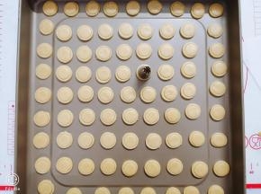 放入不沾烤盘中，然后用小一号的花嘴在圆形面片上轻轻压出小圆圈