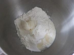 面盆中依次放入奶粉，水，糖、面粉，和面成光滑的面团且有一定的延展性。