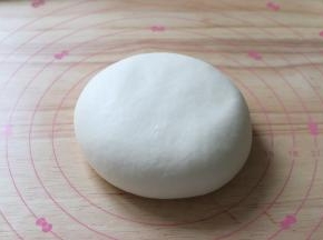 静置好的面团，压扁。面团经过静置以后，更加的细腻延展性也更好。