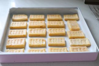 一块一块放到垫了油纸的学厨方形烤盘中，用叉子扎出小孔。