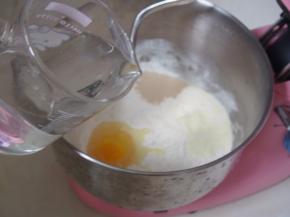 加入酵母、鸡蛋和清水，启动厨师机的低档，揉成面团至起筋