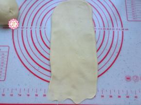 取出其中一块面团，不用静置醒面，直接擀开成成长条状，底部擀薄一些，自上而下卷起来，不能太松，也不能太紧，适当就好。