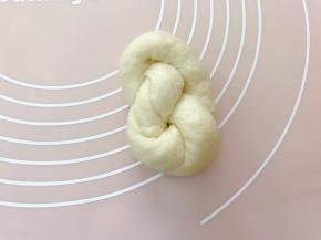 再把尾部收入，一个面包坯完成摆入烤盘里