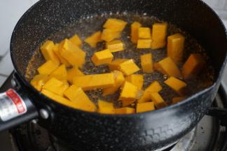 锅里的水烧开后，放入南瓜丁，煮至八成熟，捞起来