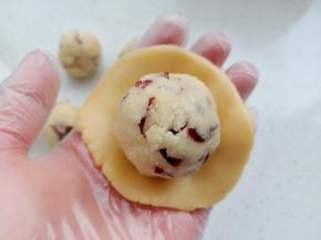 取一份面团用手压扁，包入椰蓉馅