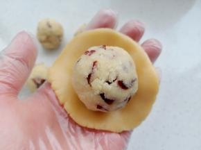 取一份面团用手压扁，包入椰蓉馅