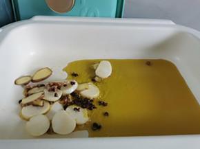 锅中倒入食用油烧热， 放入大蒜，生姜，花椒粒炒出香味