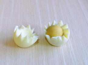 轻轻扭动鸡蛋，对半开，如图，取出蛋黄，依次做完。