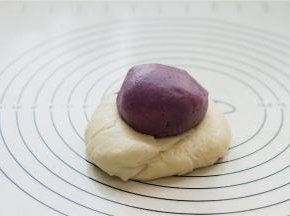 将醒好的二款面皮重叠在一起。将油酥用水油皮包裹起来。