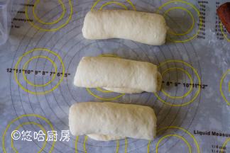 松弛后的面团上下擀长，翻面后卷起，盖保鲜膜再次松弛15分钟。