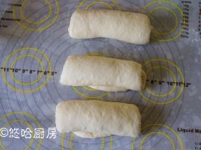 松弛后的面团上下擀长，翻面后卷起，盖保鲜膜再次松弛15分钟。