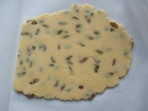 将面团放在油纸上，表面再铺一层油纸，用擀面杖擀均匀