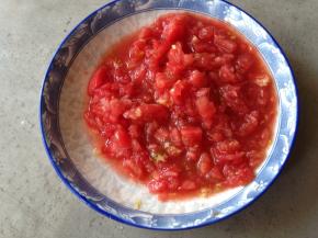 西红柿顶部切十字刀，泡入开水1分钟去皮，然后切成碎末备用，尽量切得碎一点，这样炒的时候汁水更浓郁
