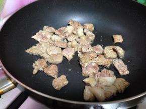 炒锅再加油倒入牛肉丁和料酒炒至变色，煸炒牛肉目的是初步去腥