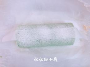 用油纸剪出一条油纸条，码在蛋糕卷上，然后用筛网，筛上防潮糖粉，筛好时，轻轻的把油纸移开，移的时候要小心点，以免糖粉散落