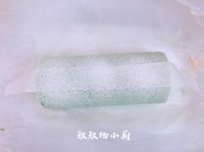用油纸剪出一条油纸条，码在蛋糕卷上，然后用筛网，筛上防潮糖粉，筛好时，轻轻的把油纸移开，移的时候要小心点，以免糖粉散落