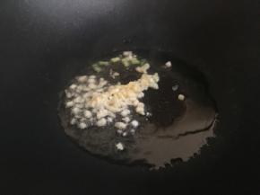 起锅热油，倒入蒜末、葱白，煸炒至蒜末边缘微黄；