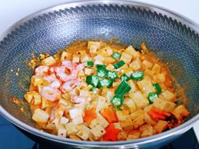 再加入秋葵，熟虾仁，胡萝卜片，小火炒1分钟关火出锅。