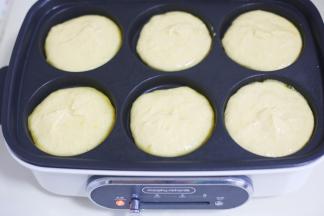 放入多功能锅的模具中，底部撒少许椰蓉，先放入一半面糊，