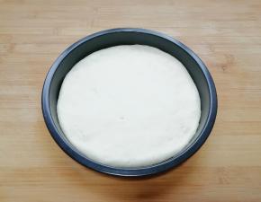 擀成和披萨盘一般大小的面饼，放入披萨盘里。