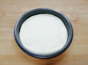 擀成和披萨盘一般大小的面饼，放入披萨盘里。